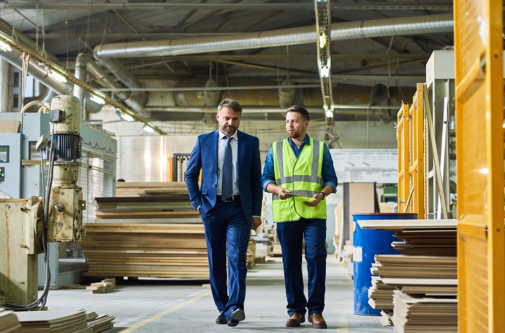 Mature-Businessman-Inspecting-Modern-Factory